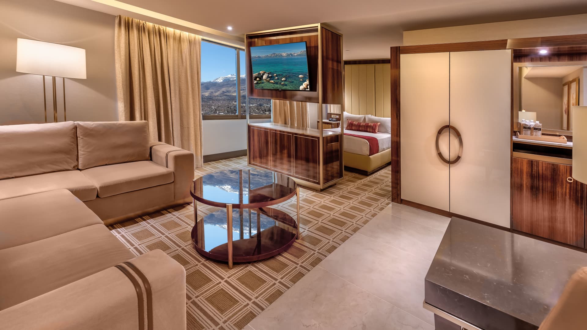 A wide view of a hotel suite with a living area and bedroom.