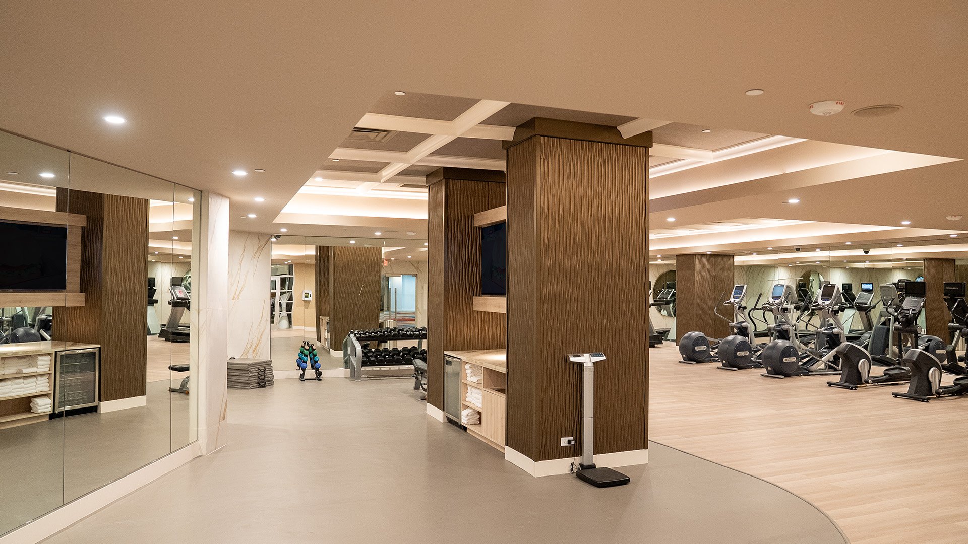 a large gym with exercise equipment and a tv